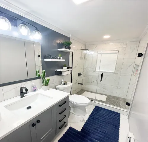 a bathroom with a sink shower and a mirror