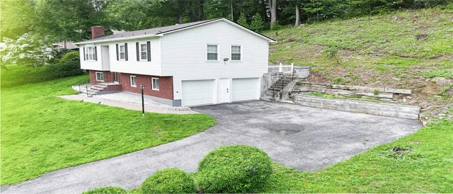 a view of a house with a yard and sitting area