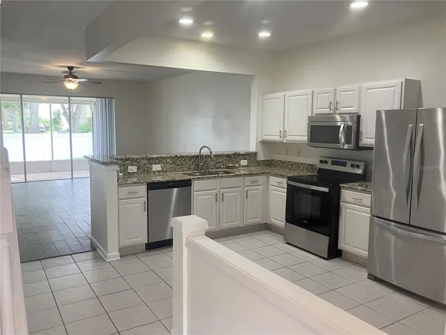 a kitchen with stainless steel appliances granite countertop a stove a sink and a refrigerator