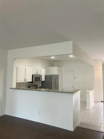 a kitchen with stainless steel appliances granite countertop a refrigerator sink and microwave