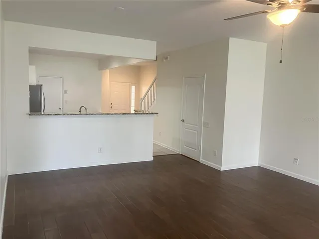 an empty room with wooden floor and mirror on th wall