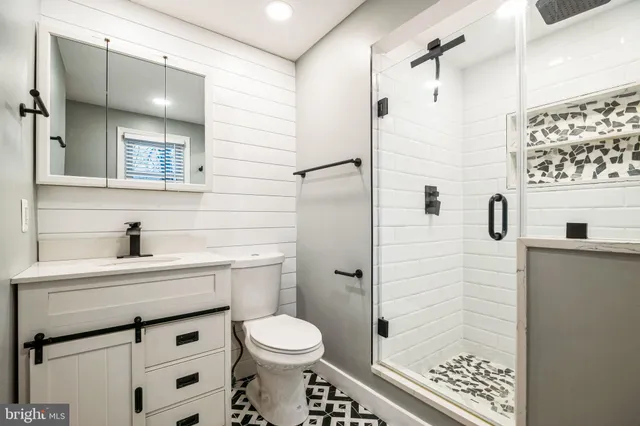 a bathroom with a sink a toilet and shower