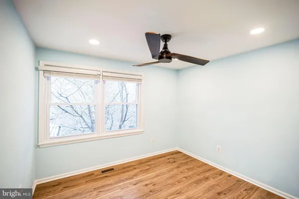 a view of empty room with window and wooden floor