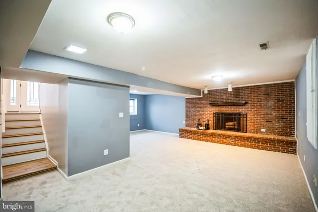 an empty room with fireplace and windows