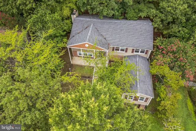 an aerial view of a house with swimming pool and garden space