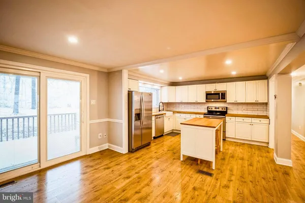 a kitchen with stainless steel appliances kitchen island granite countertop a refrigerator and stove top oven