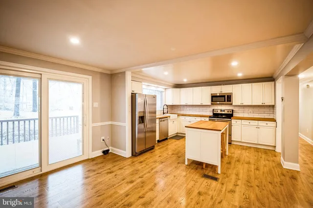 a kitchen with stainless steel appliances kitchen island granite countertop a refrigerator and stove top oven