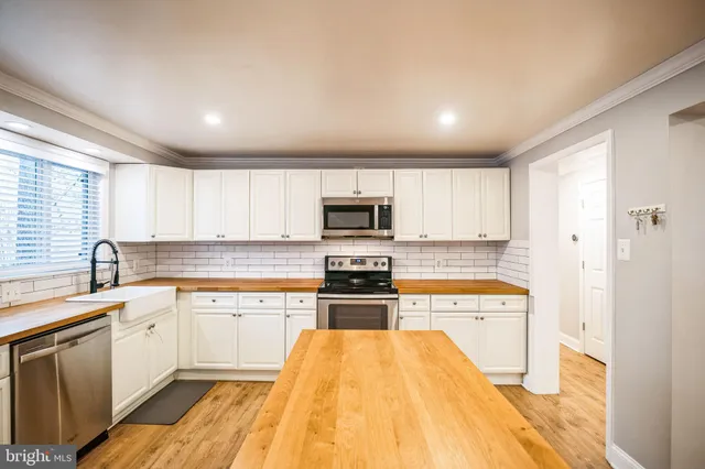 a large kitchen with stainless steel appliances granite countertop a stove and a sink
