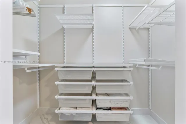 a view of walk in closet with empty racks