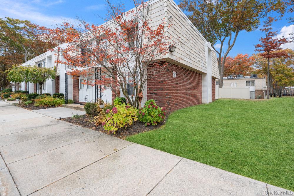 55 Rocky Point Yaphank Road, Unit 38 Rocky Point, NY 11764 - Photo 4 of 25 a front view of a house with a garden and trees