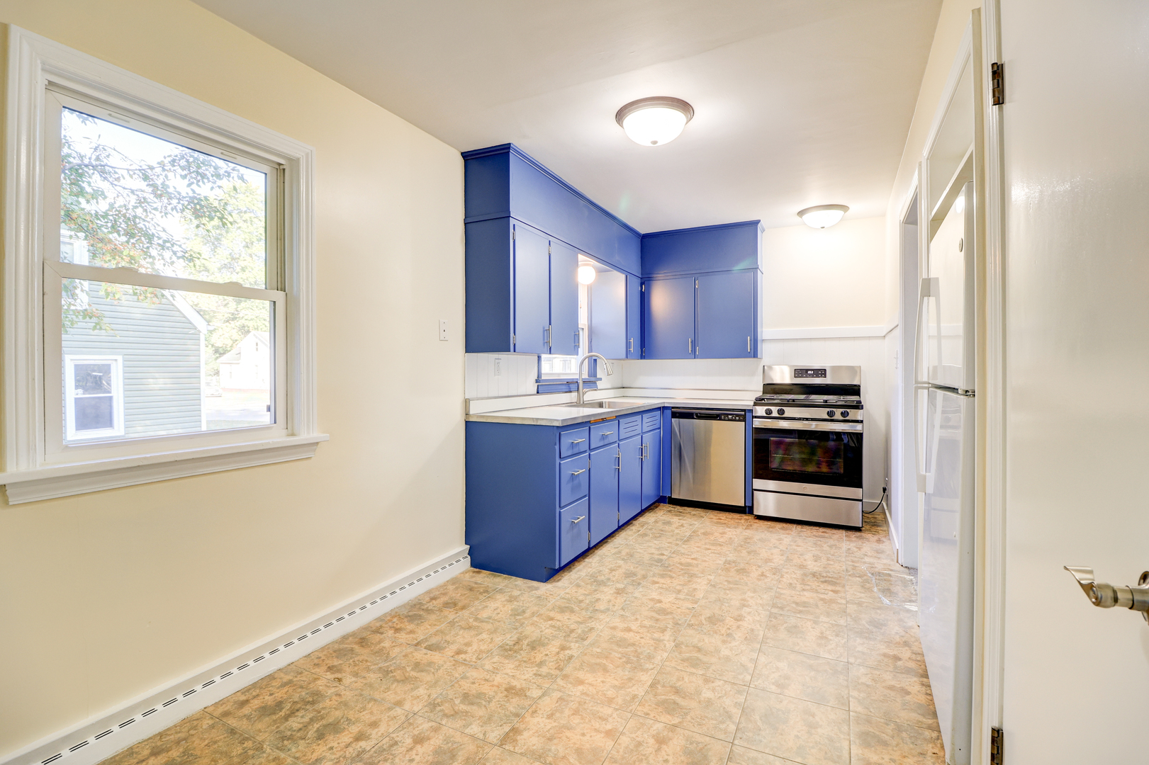 1013 West 8th Street Sterling, IL 61081 - Photo 10 of 22 a kitchen with stainless steel appliances kitchen island granite countertop a refrigerator stove and sink
