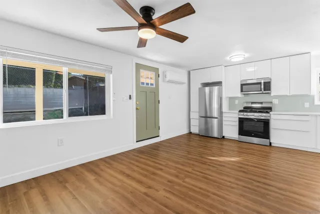 a view of a kitchen with a sink and stainless steel appliances