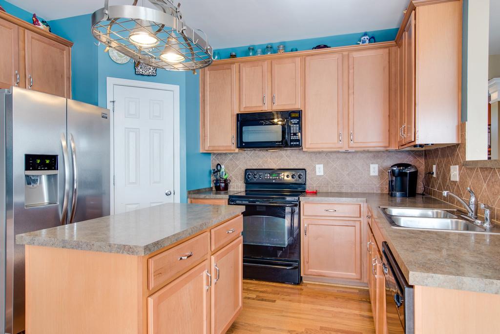 4029 Williford Way Spring Hill, TN 37174 - Photo 7 of 22 a kitchen with stainless steel appliances granite countertop a sink a stove and a refrigerator