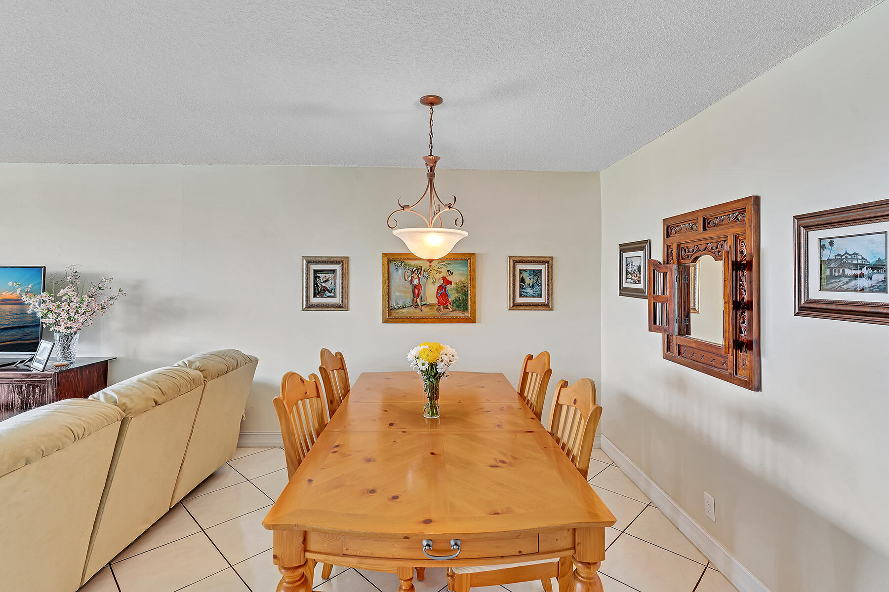 3091 North Course Drive, Unit 108 Pompano Beach, FL 33069 - Photo 12 of 42 a living room with furniture a table and a chandelier
