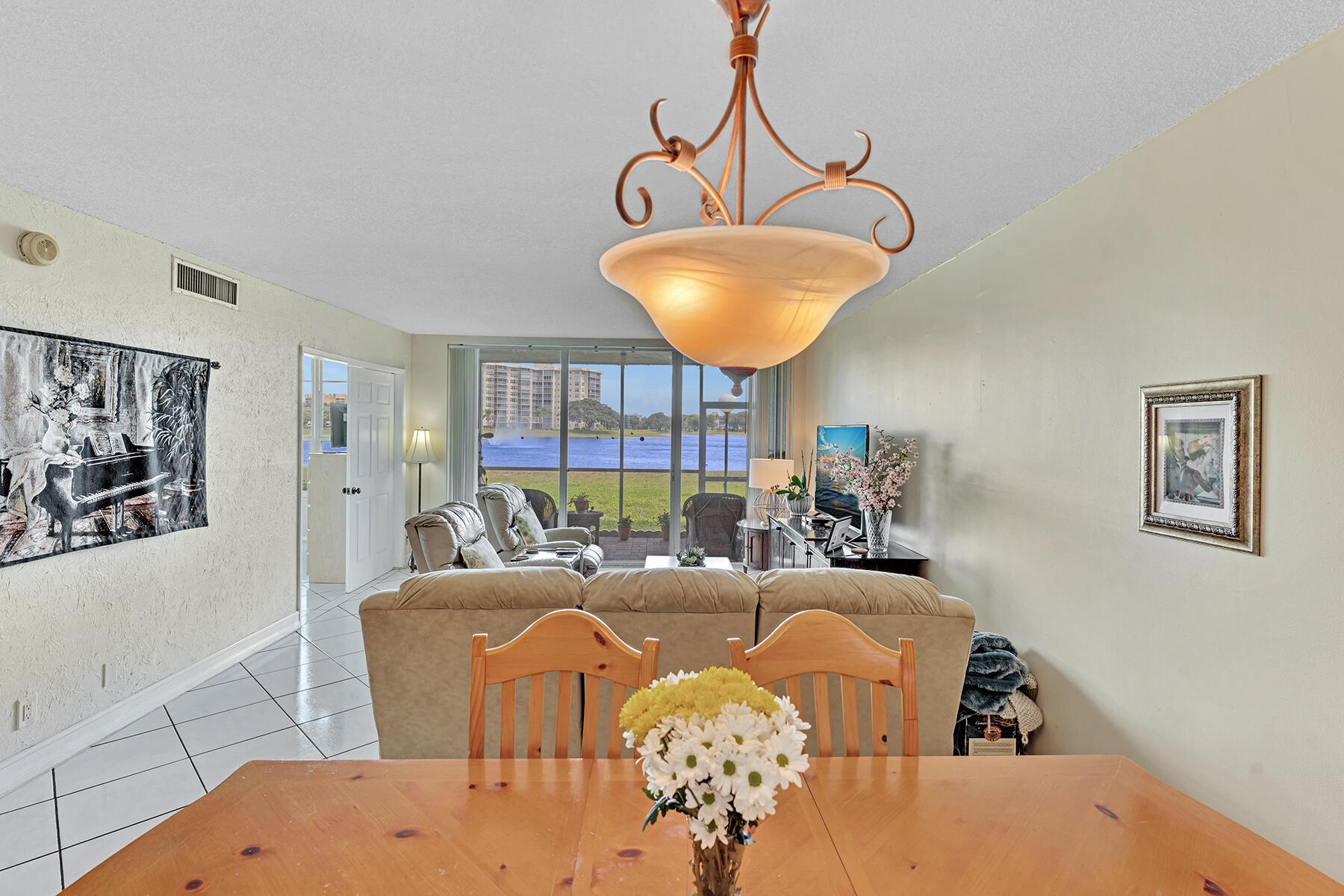 3091 North Course Drive, Unit 108 Pompano Beach, FL 33069 - Photo 13 of 42 a living room with furniture and a chandelier