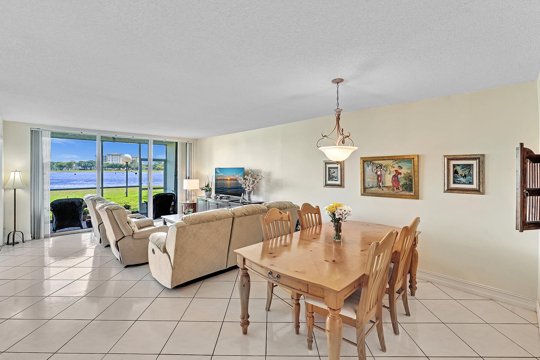 3091 North Course Drive, Unit 108 Pompano Beach, FL 33069 - Photo 14 of 42 a living room with furniture a chandelier and a dining table