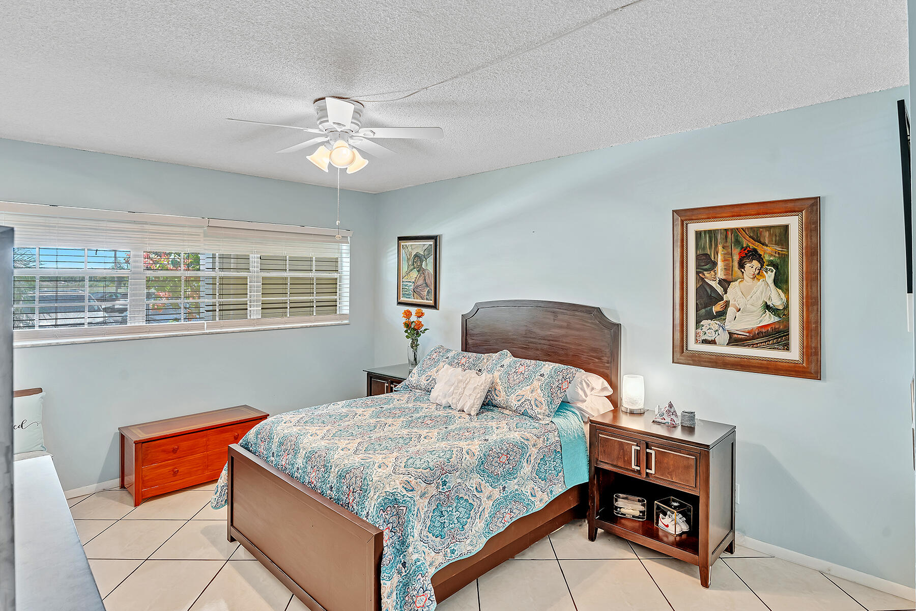 3091 North Course Drive, Unit 108 Pompano Beach, FL 33069 - Photo 16 of 42 a bedroom with a bed and a chandelier