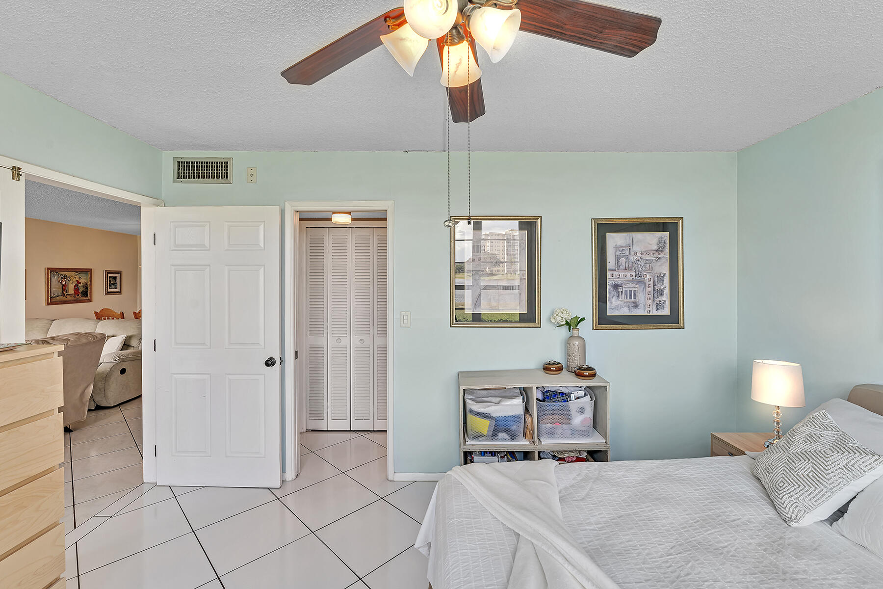 3091 North Course Drive, Unit 108 Pompano Beach, FL 33069 - Photo 27 of 42 a bedroom with a bed and a chandelier