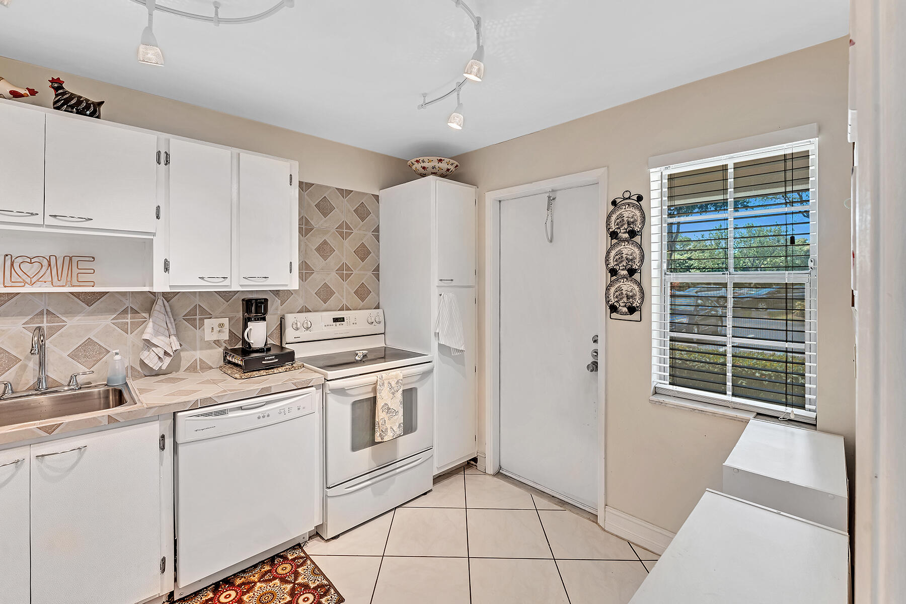 3091 North Course Drive, Unit 108 Pompano Beach, FL 33069 - Photo 7 of 42 a kitchen with white cabinets and white appliances