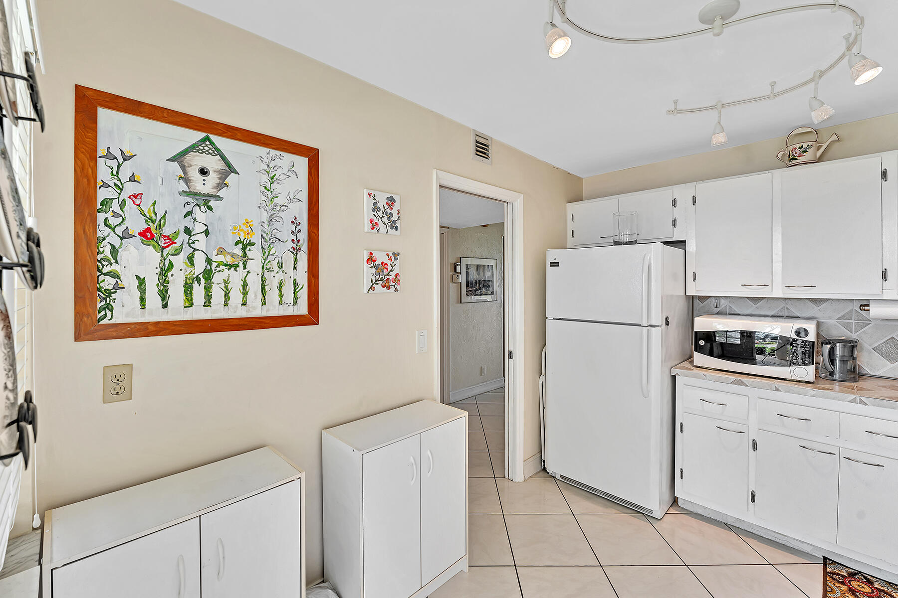 3091 North Course Drive, Unit 108 Pompano Beach, FL 33069 - Photo 10 of 42 a kitchen with cabinets stainless steel appliances a refrigerator and a stove top oven