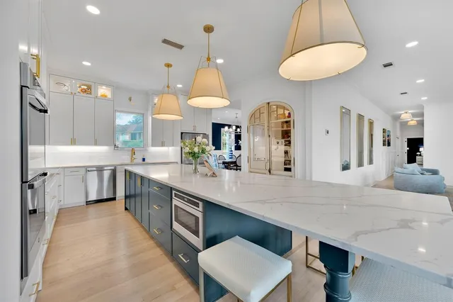 a large kitchen with stainless steel appliances a large counter space