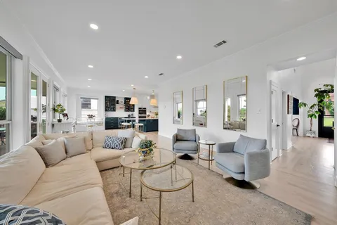 a living room with furniture and view of kitchen
