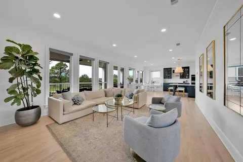 a living room with furniture potted plant with kitchen view