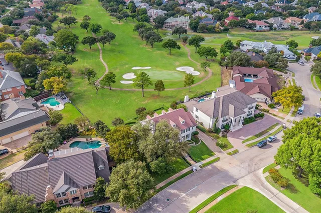 an aerial view of residential houses with outdoor space and lake view