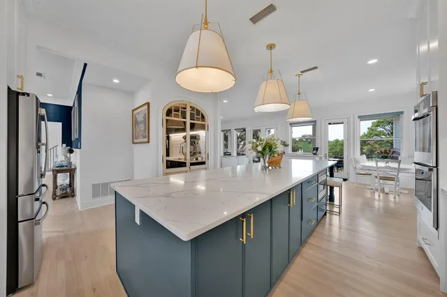 a kitchen with stainless steel appliances kitchen island a large island in the center