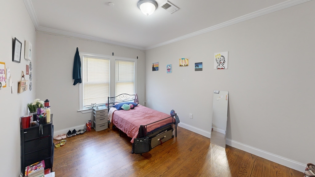 2973 Washington Street, Unit 2 Boston, MA 02119 - Photo 3 of 6 a bedroom with a bed and wooden floor