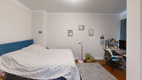a bedroom with a bed and a wooden floor
