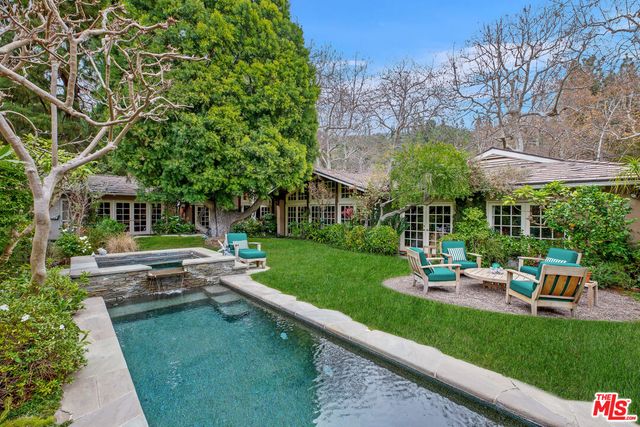 a view of a house with a yard patio and fire pit