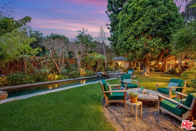 an outdoor sitting area with couch and wooden fence