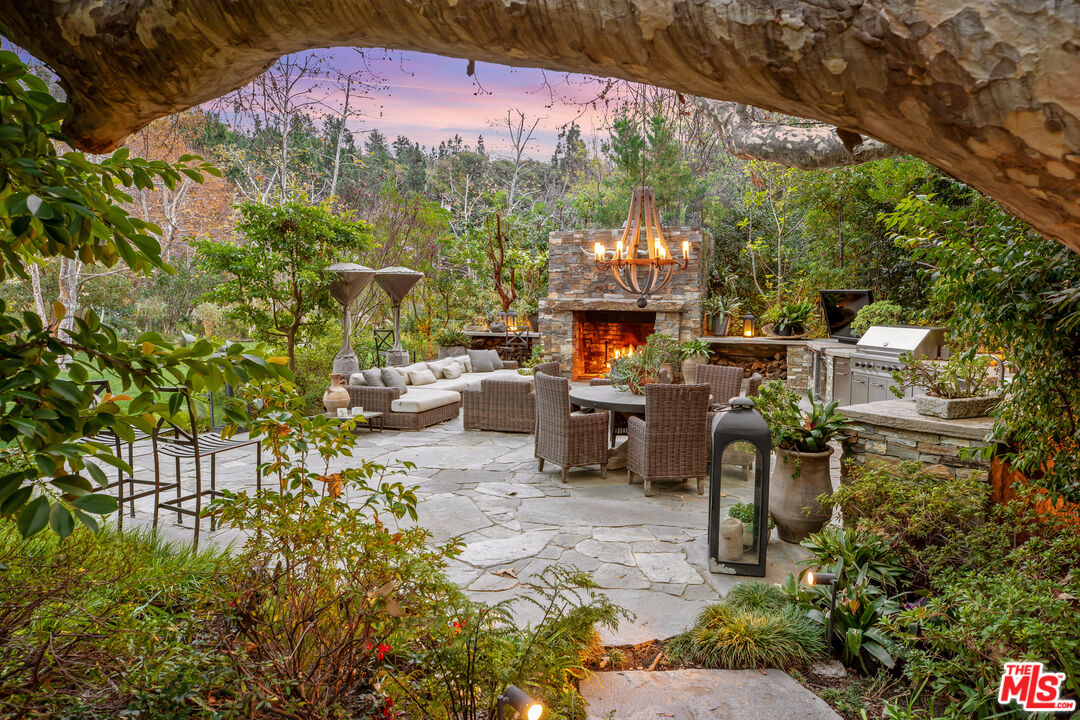 2383 Mandeville Canyon Road Los Angeles, CA 90049 - Photo 46 of 51 a view of a patio with table and chairs and potted plants