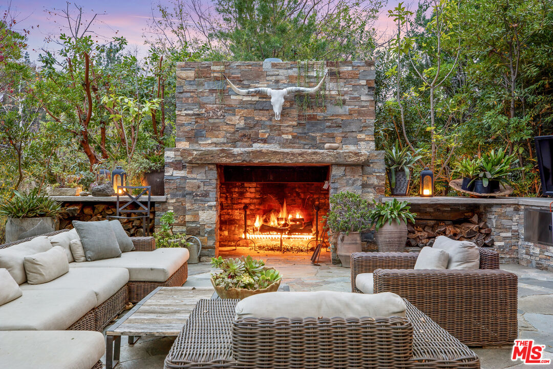 2383 Mandeville Canyon Road Los Angeles, CA 90049 - Photo 47 of 51 a view of a patio with couches and a fireplace