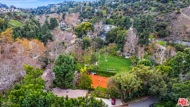 an aerial view of residential house with outdoor space and trees all around
