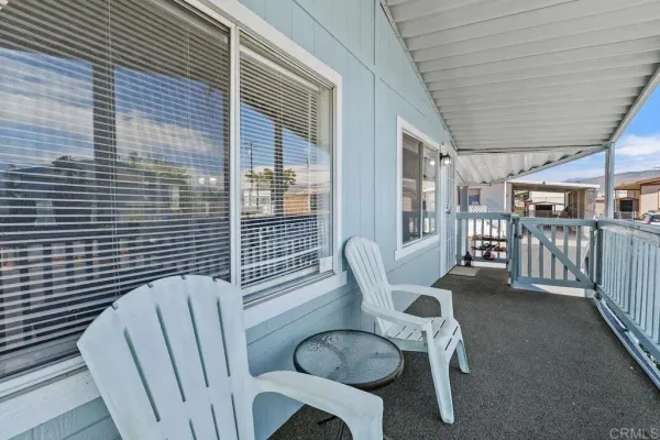 a kitchen with stainless steel appliances granite countertop a refrigerator a sink a stove a dining table and chairs
