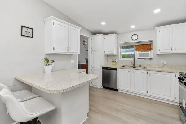 a kitchen with granite countertop a refrigerator and a sink