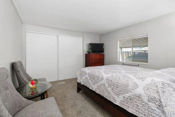 a bed sitting in a bedroom next to a window