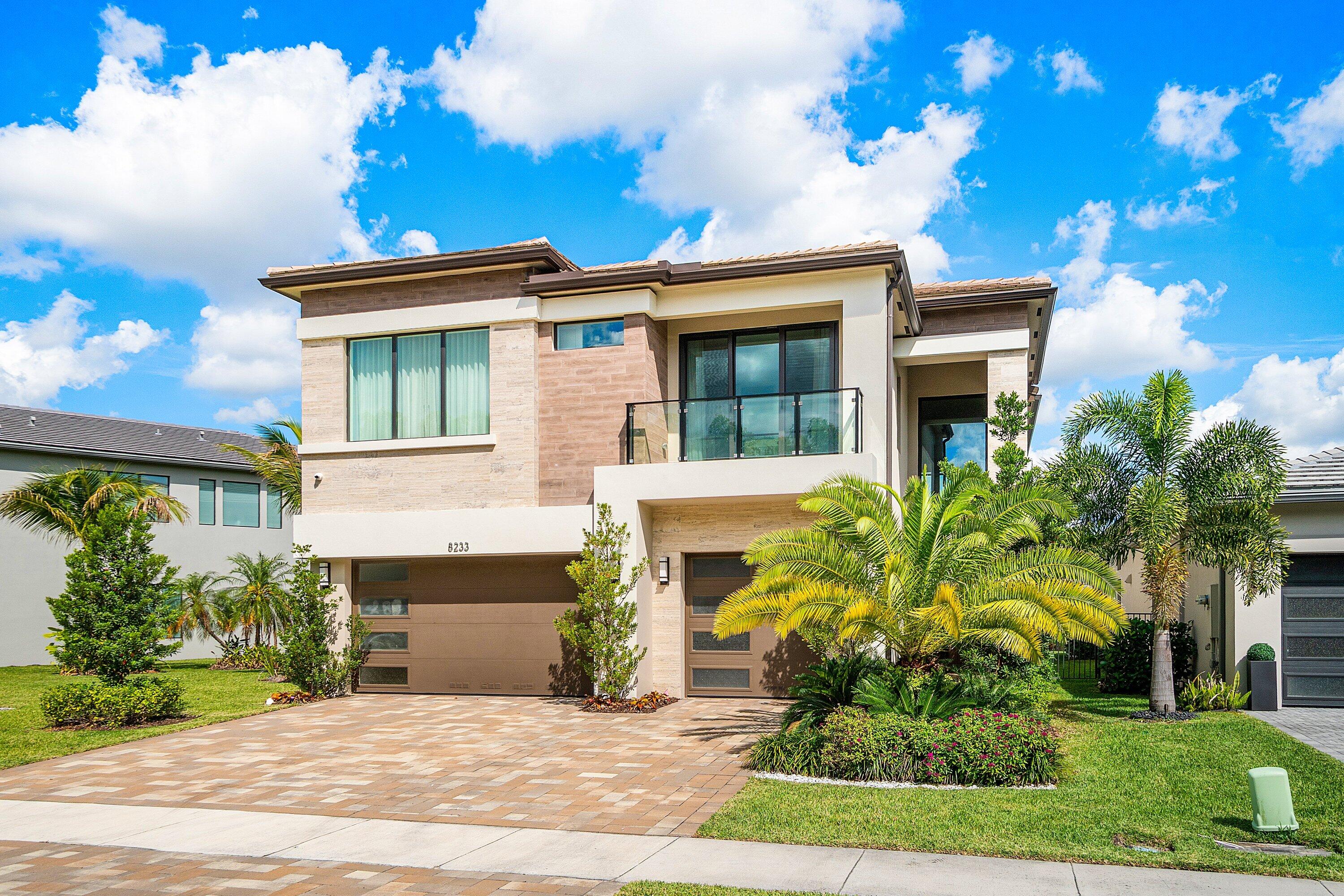 8233 Crystal Downs Avenue Boca Raton, FL 33434 - Photo 2 of 58 a front view of a house with a yard