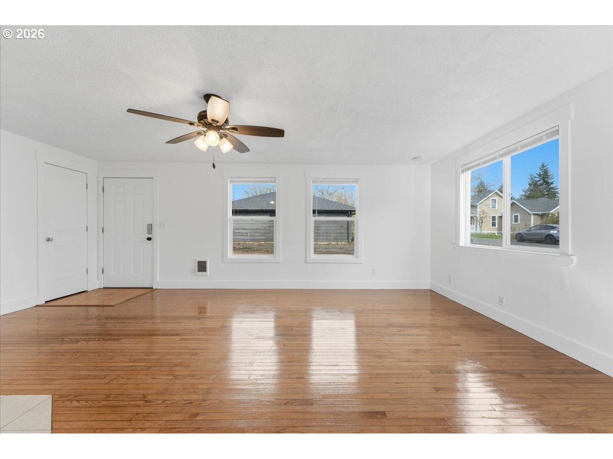 369 South 16th Avenue Cornelius, OR 97113 - Photo 15 of 29 a view of an empty room with chandelier fan and wooden floor