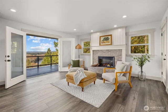 a living room with furniture a large window and a fireplace