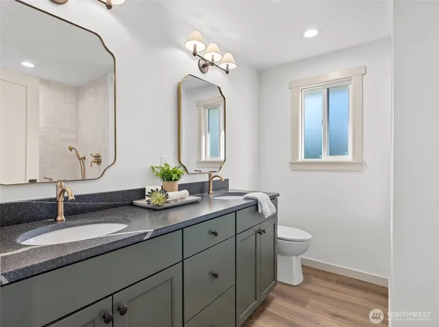a bathroom with a granite countertop sink a toilet and a mirror