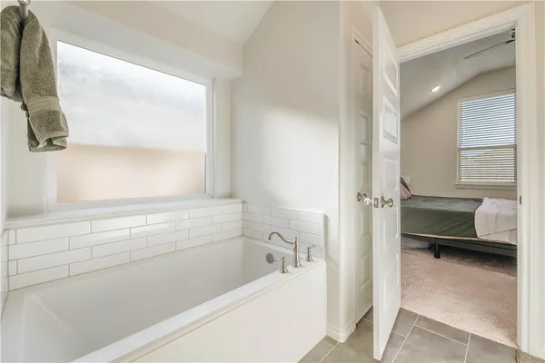 a bathroom with a bathtub and a window