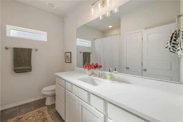 a bathroom with a sink a toilet and mirror