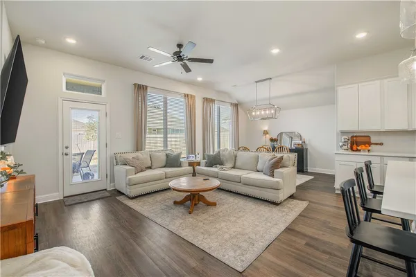 a living room with furniture flat screen tv and a large window