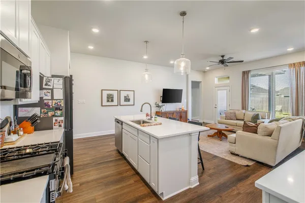 a kitchen with counter top space sink stove and wooden floor