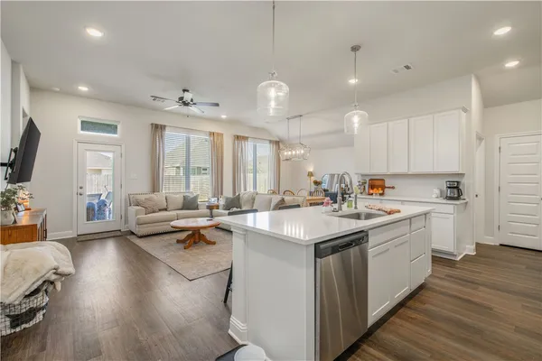 a kitchen with counter top space sink stove and wooden floor