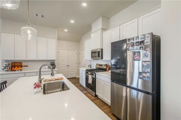 a kitchen with stainless steel appliances a refrigerator sink and microwave