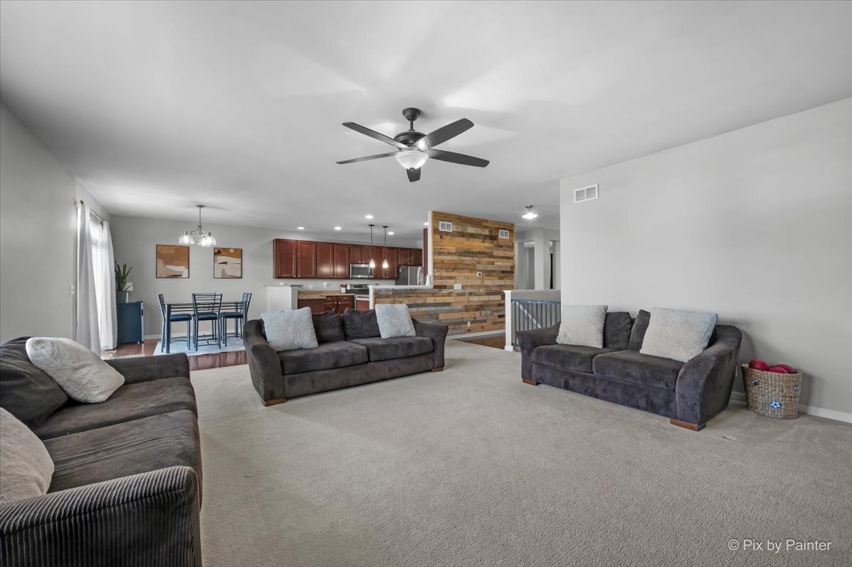 691 Windett Ridge Road Yorkville, IL 60560 - Photo 8 of 42 a living room with furniture ceiling fan and a rug